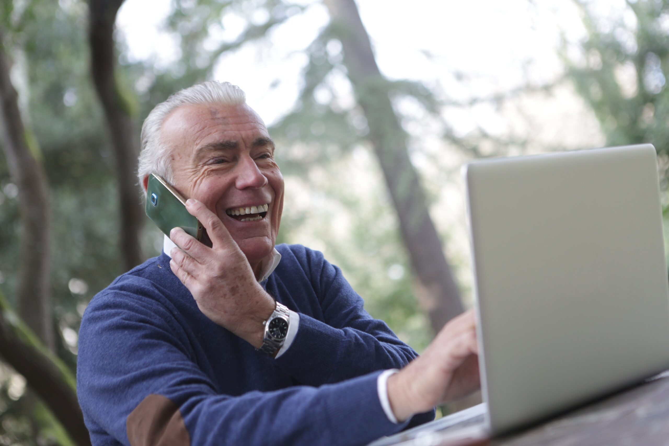 anziano con smartphone e computer